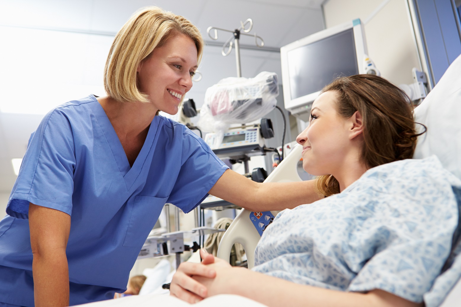 Female Patient Talking to Nurse In Emergency Room